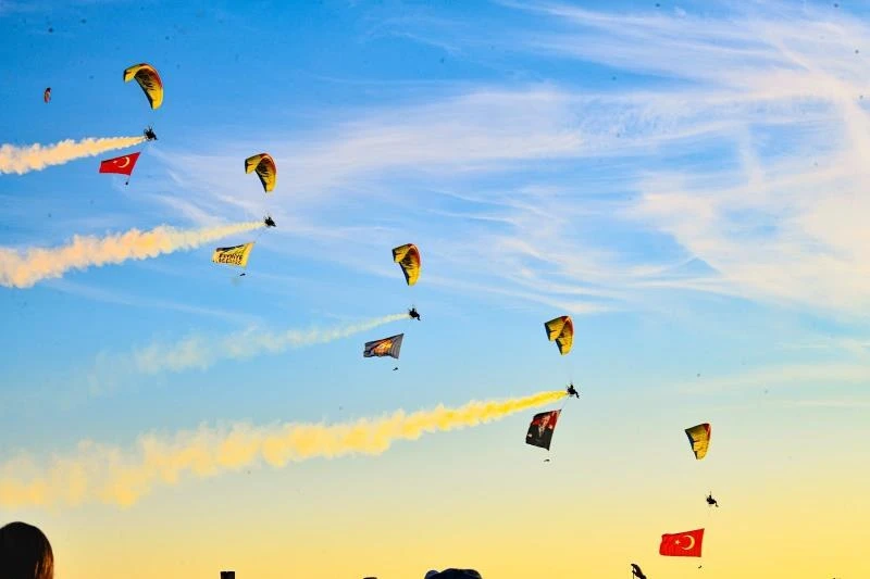 Ölüdeniz Hava Oyunları Festivali'nde duman izi bırakan ve bayrak taşıyan motorlu yamaç paraşütleri
