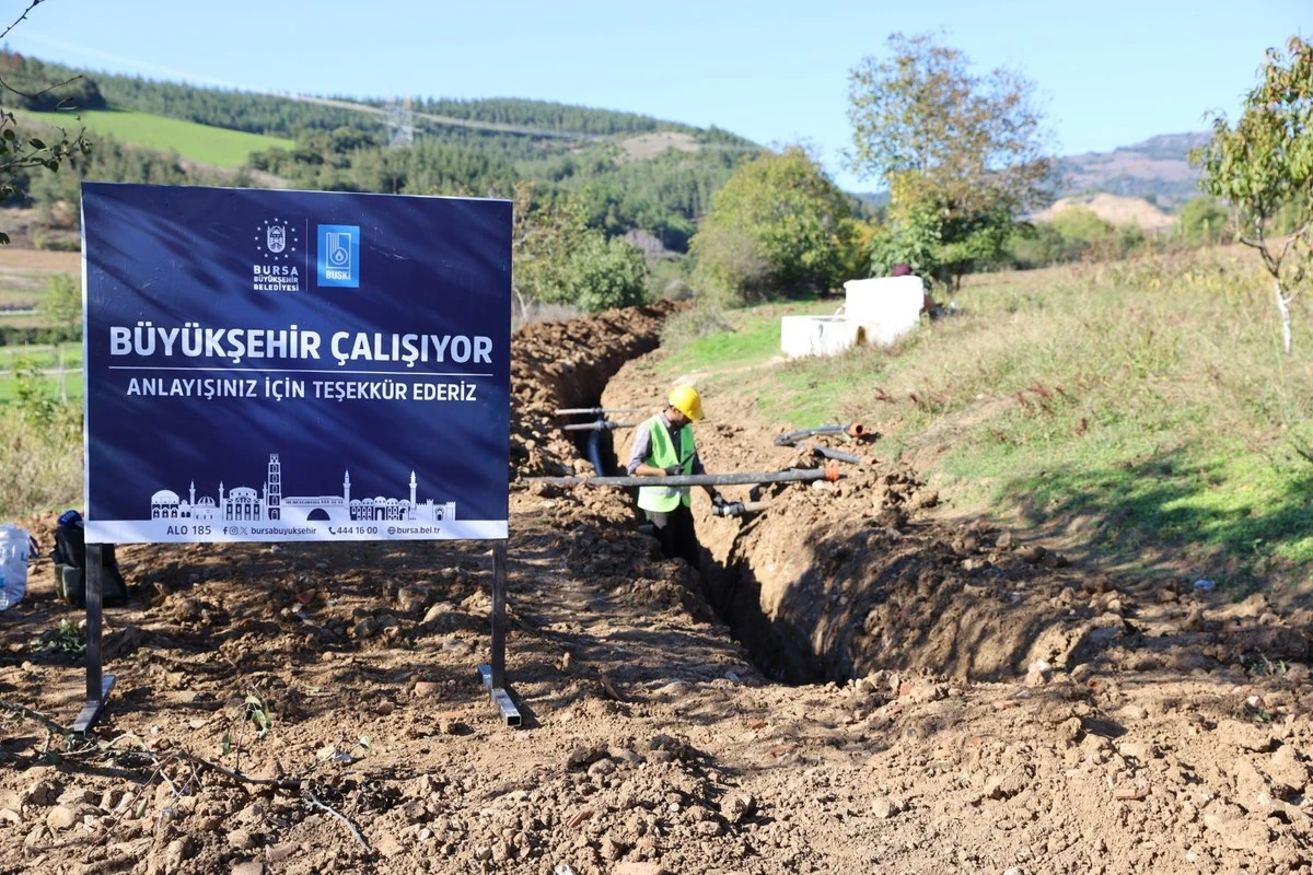 Yenişehir Alaylı Mahallesi'nde Evkaya Deresi'nden sulama göletine uzanan boru hattı için açılan kanal ve Büyükşehir çalışma tabelası